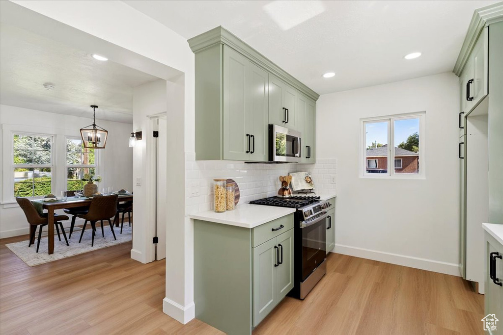Kitchen with stainless steel appliances, green cabinetry, light countertops, and recessed lighting