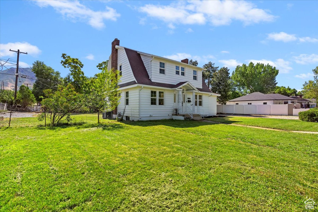 Rear view of property featuring a chimney and roof with shingles