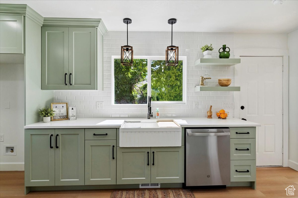 Kitchen with green cabinetry, stainless steel dishwasher, open shelves, tasteful backsplash, and light wood-type flooring