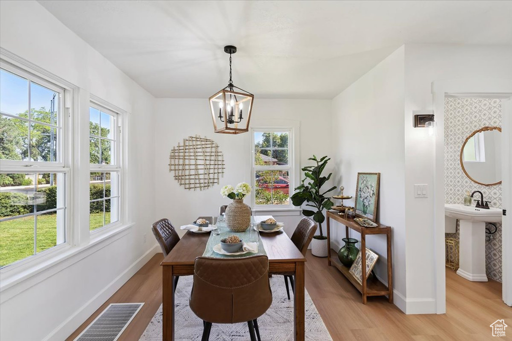 Dining area featuring a chandelier, healthy amount of natural light, and light wood-style flooring