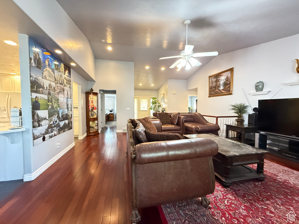 Living room with a ceiling fan, dark wood finished floors, and vaulted ceiling