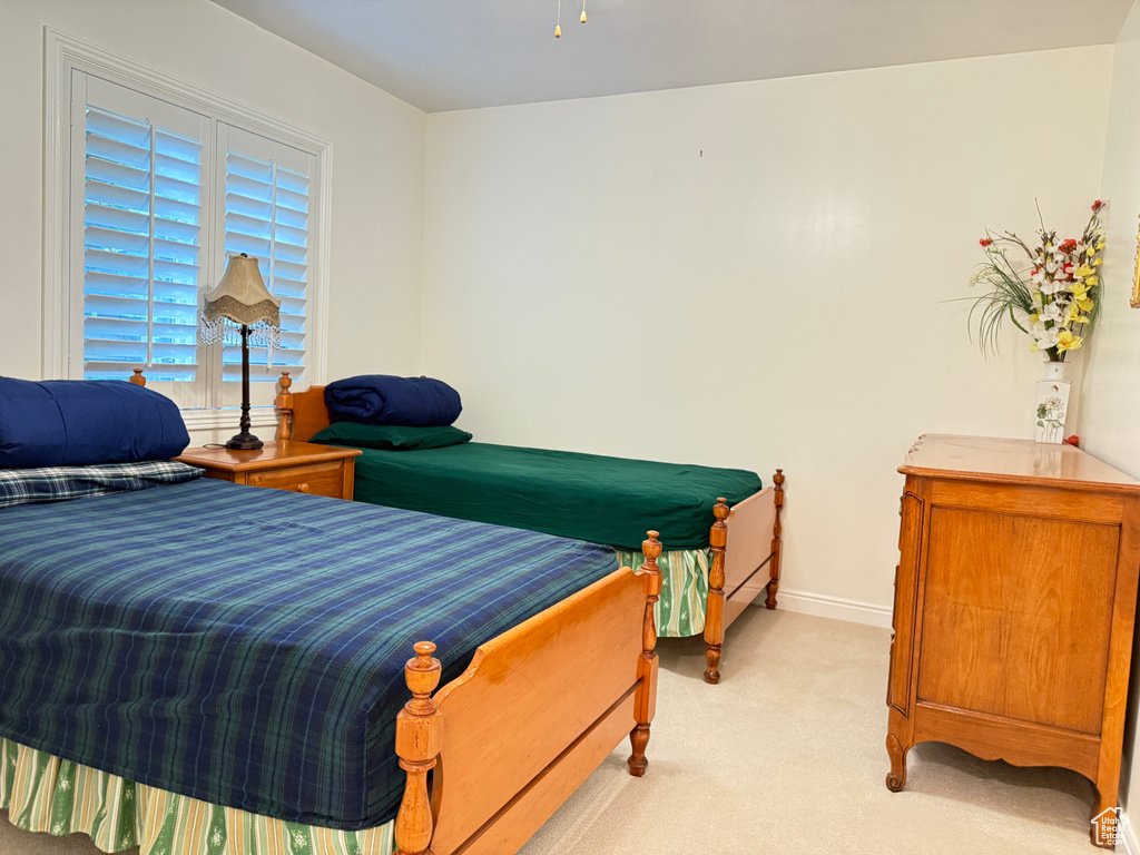 Bedroom featuring light colored carpet and baseboards