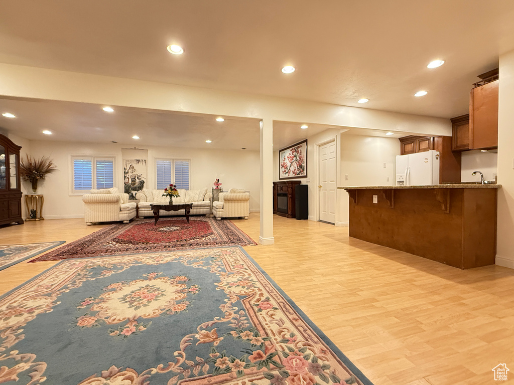 Living room with recessed lighting, light wood-style flooring, and a fireplace