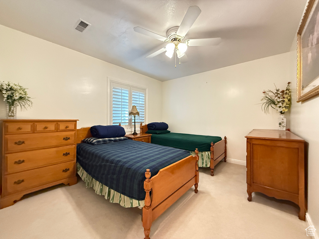 Bedroom with light carpet and ceiling fan