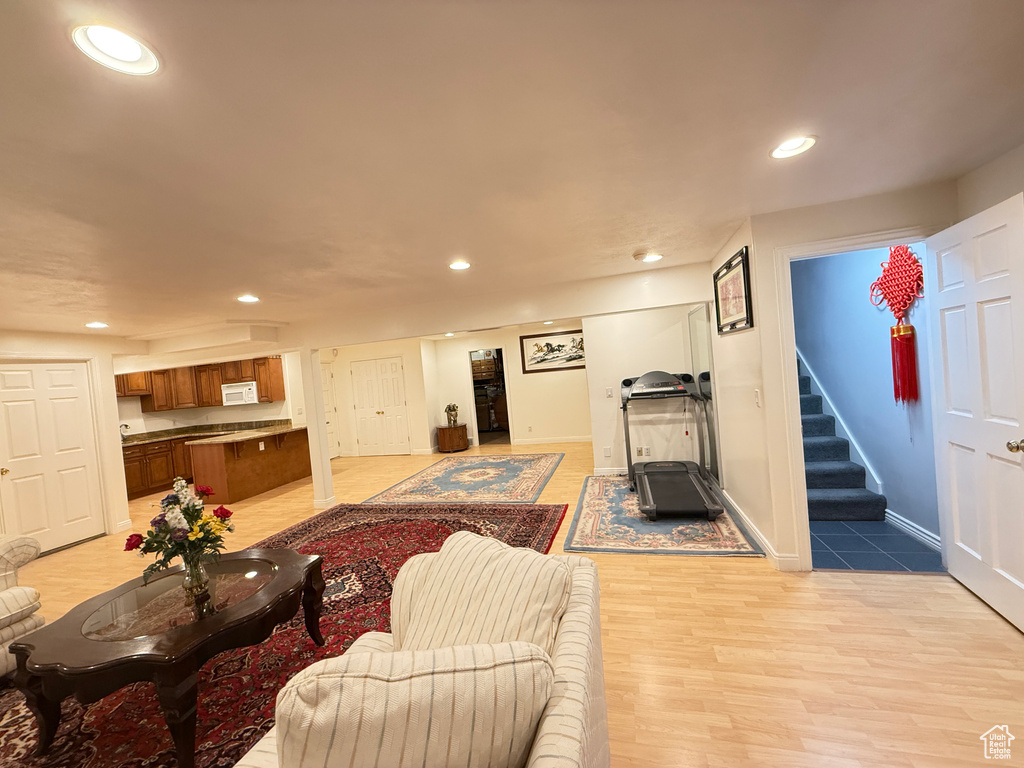Living room featuring stairs, recessed lighting, and light wood-style flooring