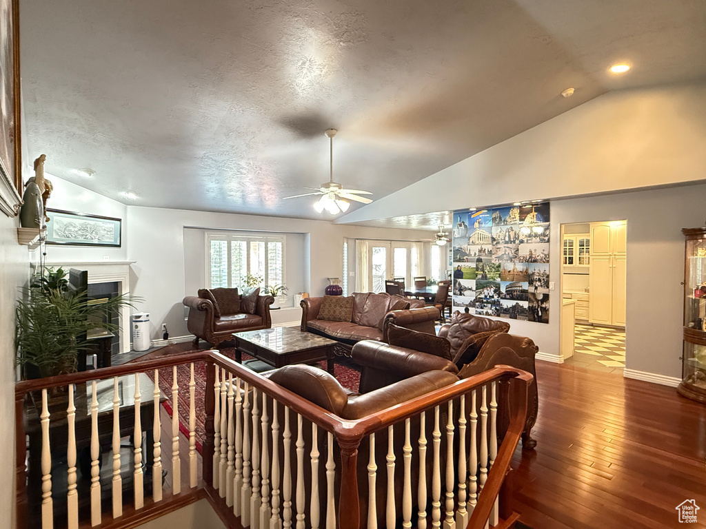 Living room with vaulted ceiling, ceiling fan, a fireplace, dark wood finished floors, and recessed lighting