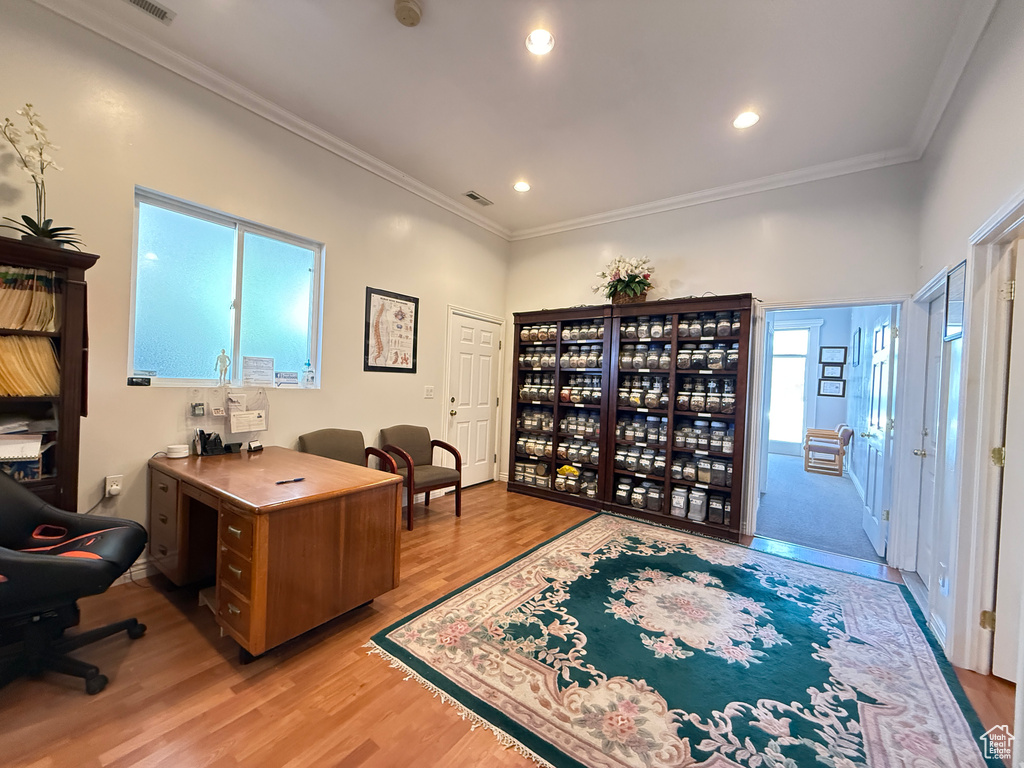 Office area featuring light wood-style floors, ornamental molding, and recessed lighting