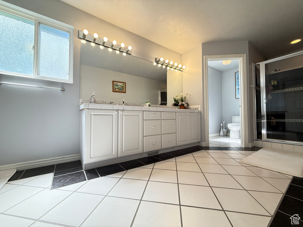 Full bathroom featuring double vanity, tile patterned flooring, a stall shower, and a bidet