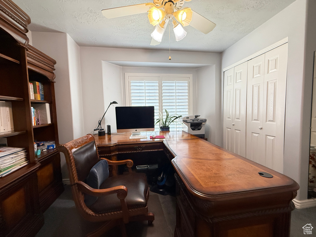 Office with ceiling fan and a textured ceiling