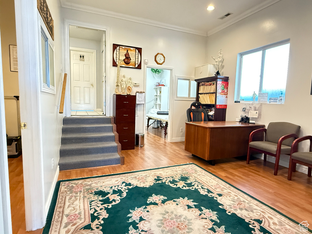 Office space with wood finished floors, ornamental molding, and recessed lighting