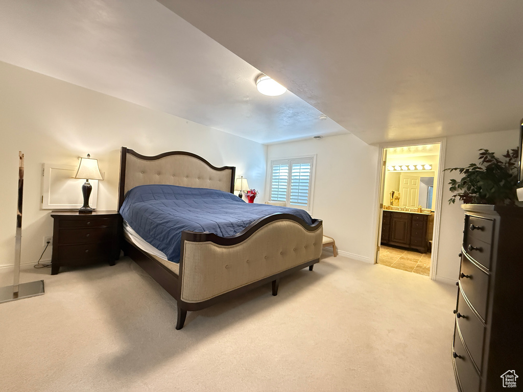 Bedroom with light carpet and ensuite bath