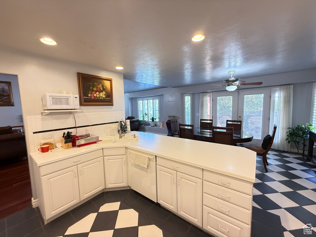 Kitchen with a peninsula, white appliances, ceiling fan, light countertops, and recessed lighting