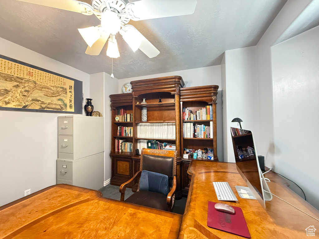 Office with a ceiling fan and baseboards