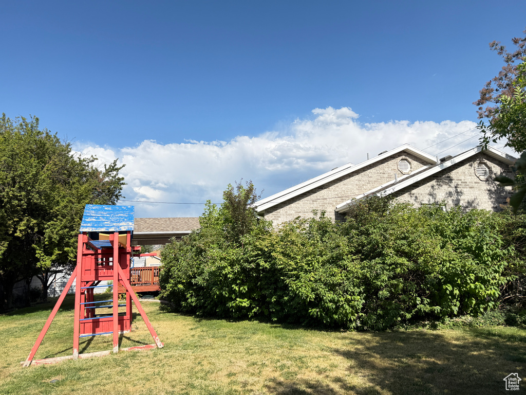 View of grassy yard featuring a playground