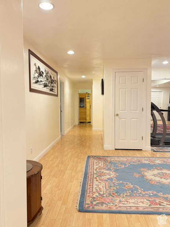 Hall with light wood-type flooring and recessed lighting