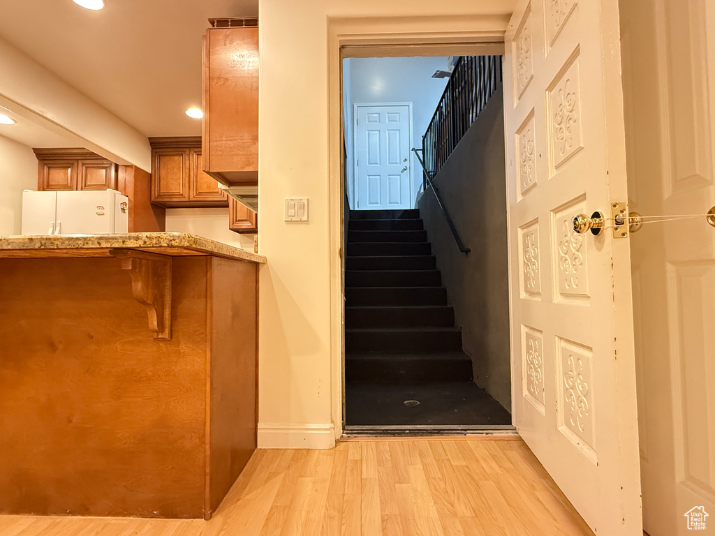 Stairway featuring wood finished floors and recessed lighting