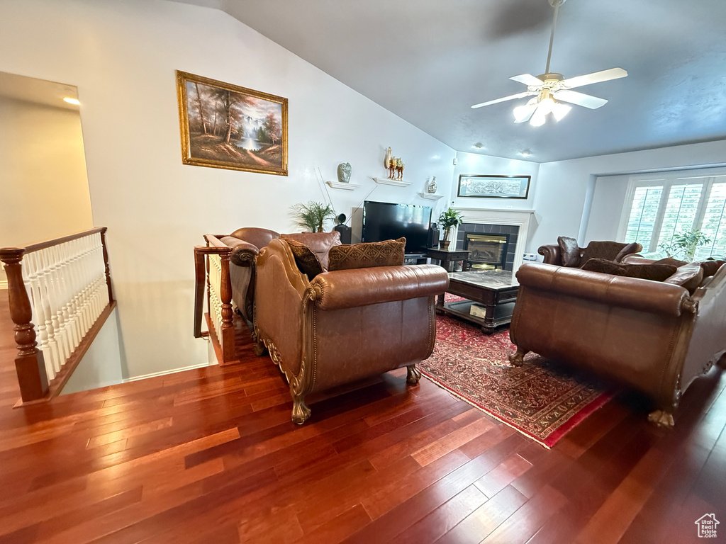 Living area with lofted ceiling, wood-type flooring, a ceiling fan, and a fireplace