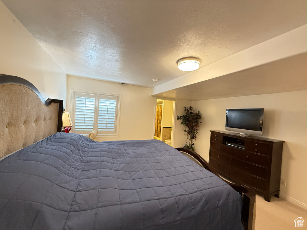 Carpeted bedroom with baseboards and a textured ceiling