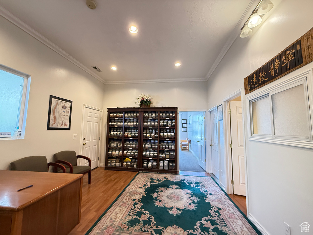 Office space featuring wood finished floors, ornamental molding, and recessed lighting