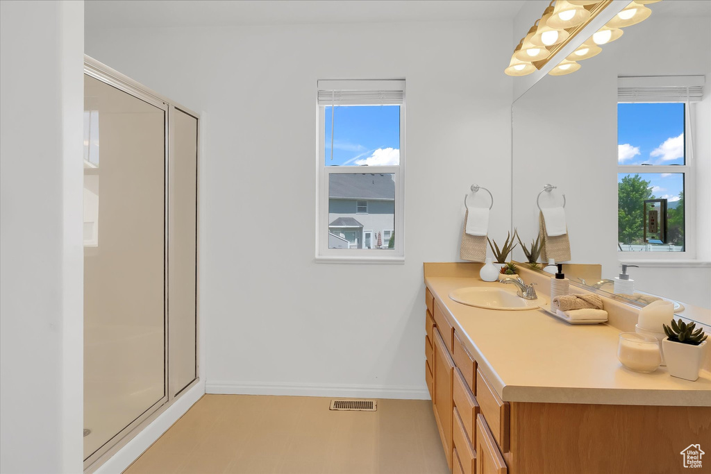 Full bathroom with vanity and a shower stall