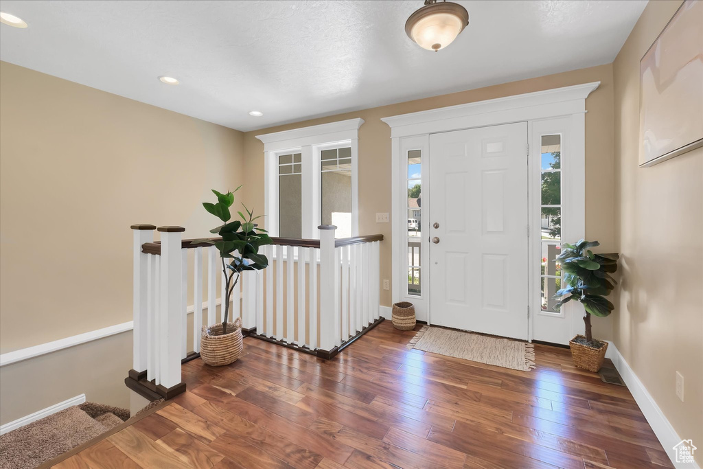 Entryway with healthy amount of natural light, wood finished floors, and recessed lighting