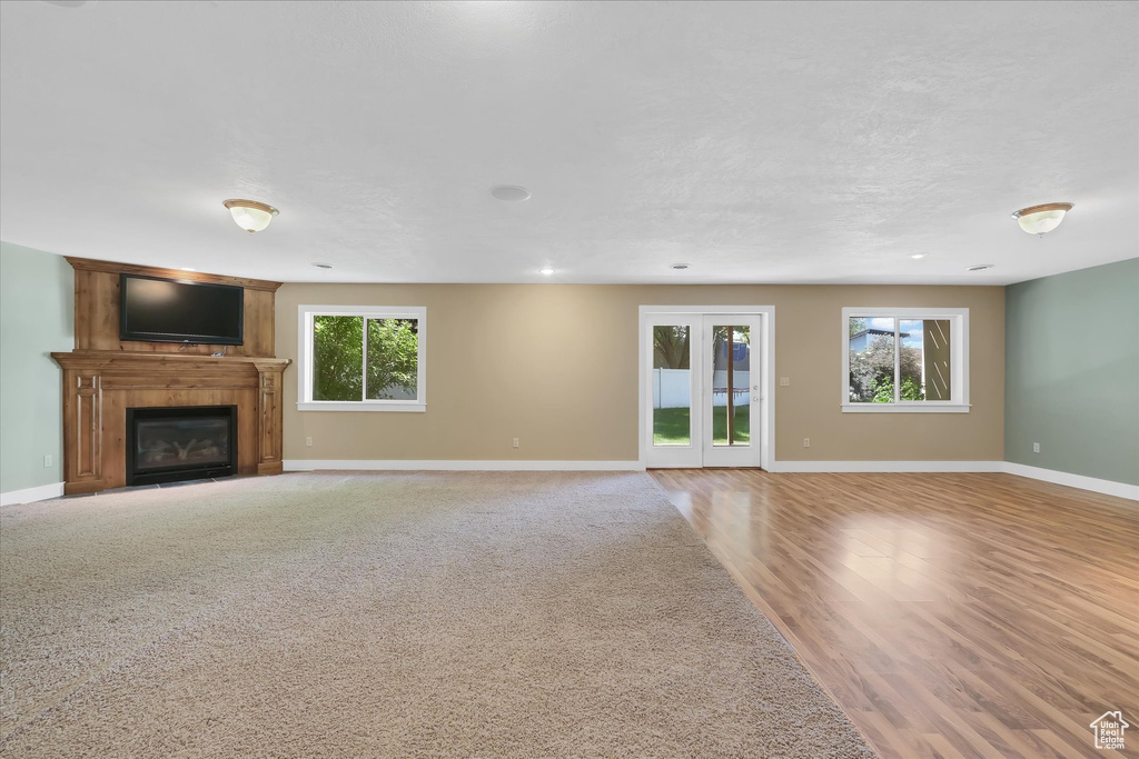 Unfurnished living room featuring a large fireplace, wood finished floors, and recessed lighting