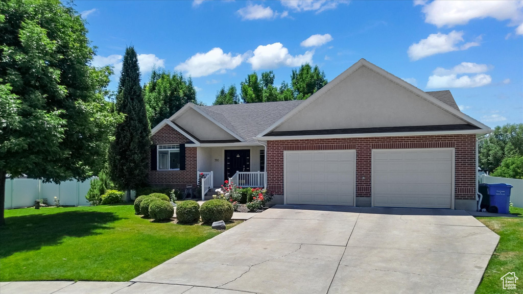 View of front of house featuring a garage, concrete driveway, and brick siding