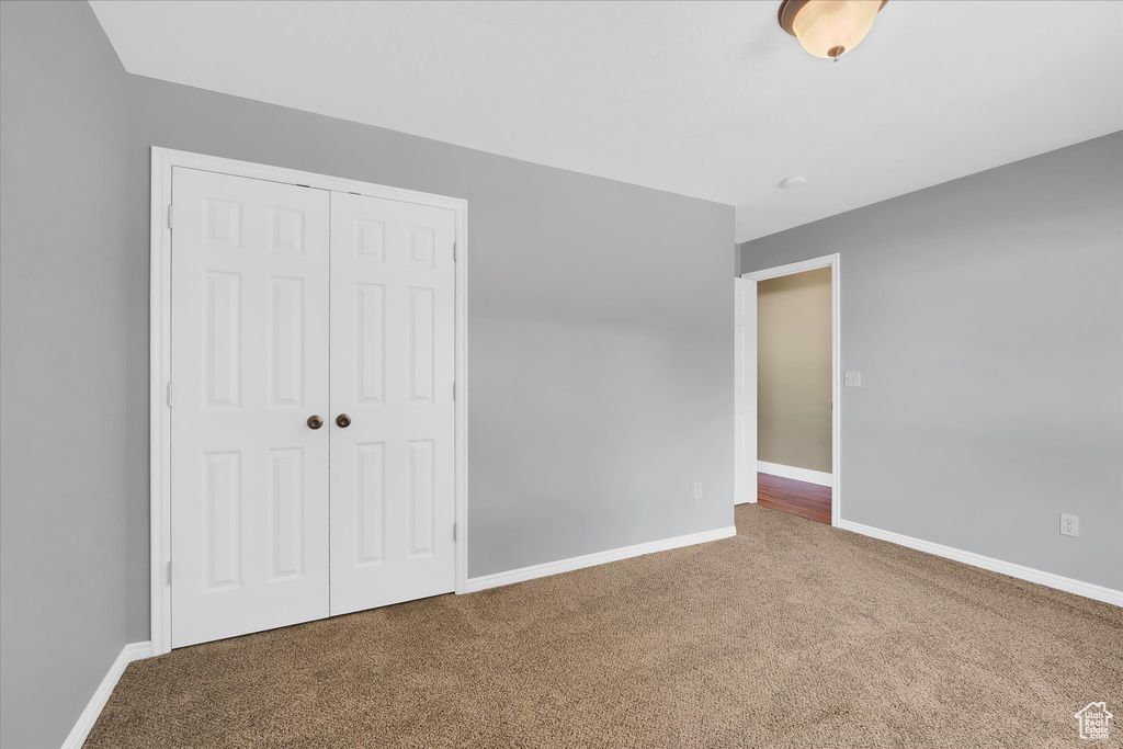 Unfurnished bedroom with carpet flooring and a closet