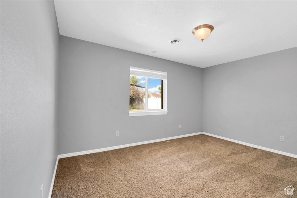 Carpeted spare room with baseboards