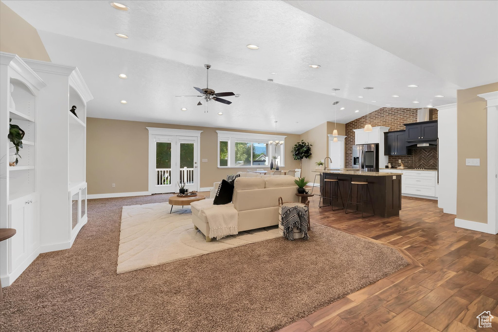Living room featuring lofted ceiling, ceiling fan, dark wood finished floors, and recessed lighting