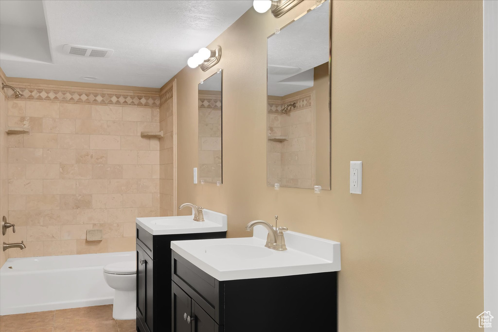 Bathroom featuring tile patterned flooring, two vanities, and shower / bath combination