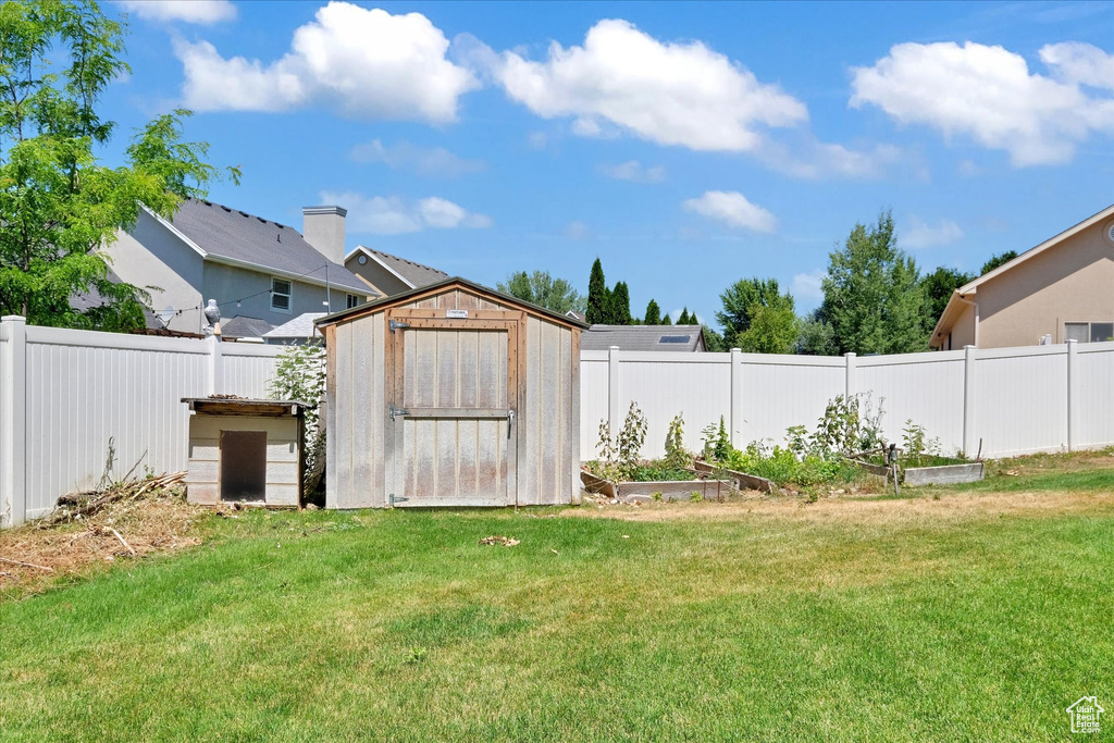 Fenced backyard with a vegetable garden and a storage unit