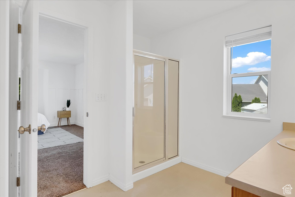 Ensuite bathroom featuring a shower stall and vanity