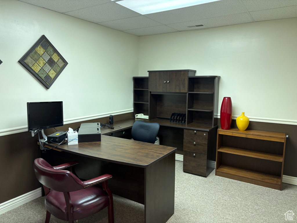 Carpeted office with a paneled ceiling