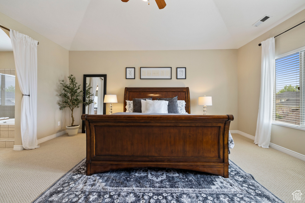 Carpeted bedroom featuring lofted ceiling and a ceiling fan