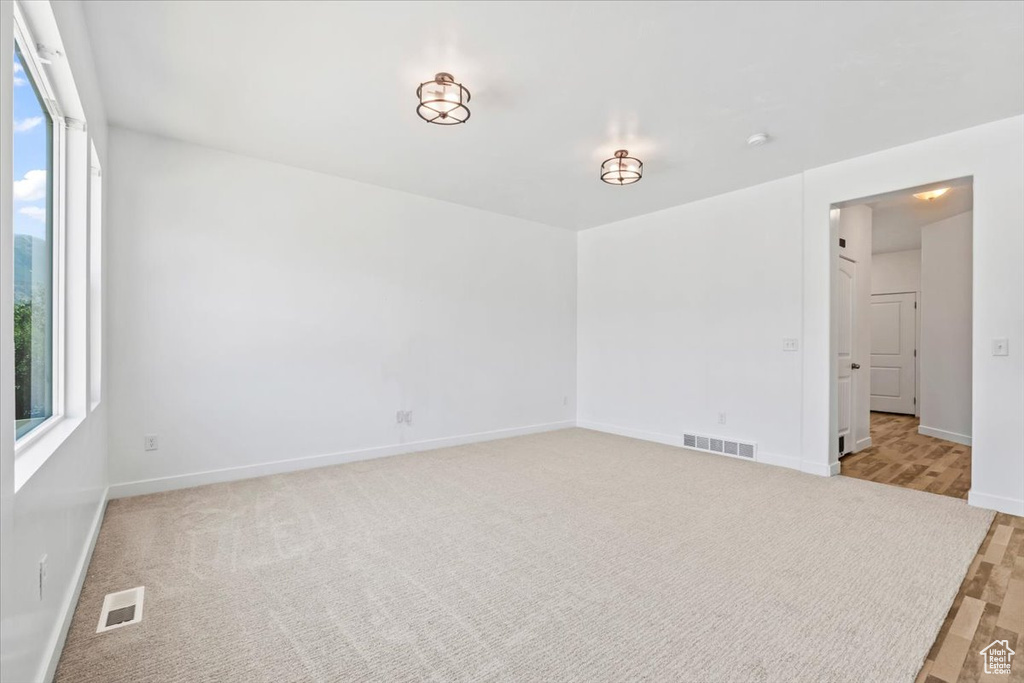 Empty room featuring baseboards and light carpet