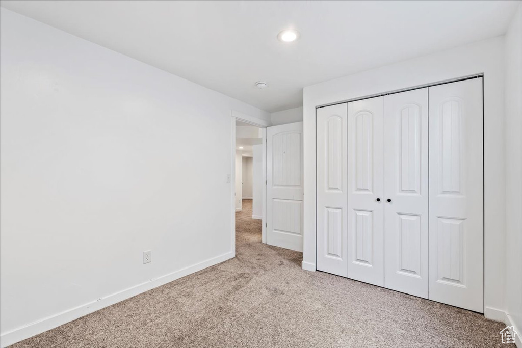Unfurnished bedroom featuring carpet flooring, a closet, and recessed lighting