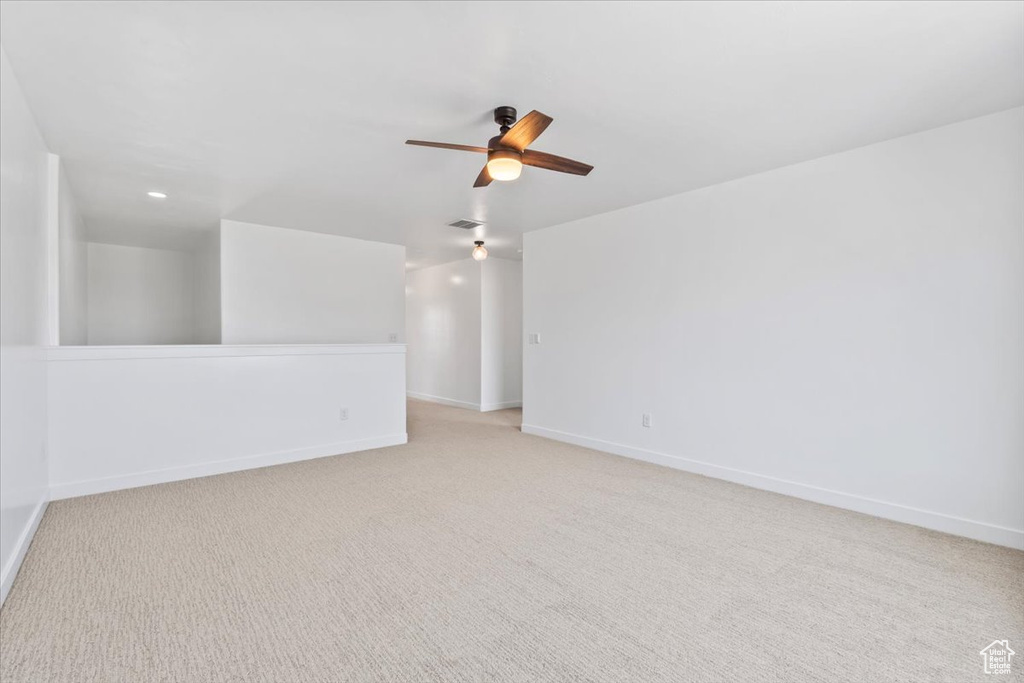 Spare room with ceiling fan and light colored carpet