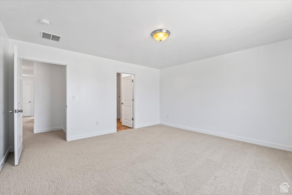 Unfurnished bedroom with light carpet