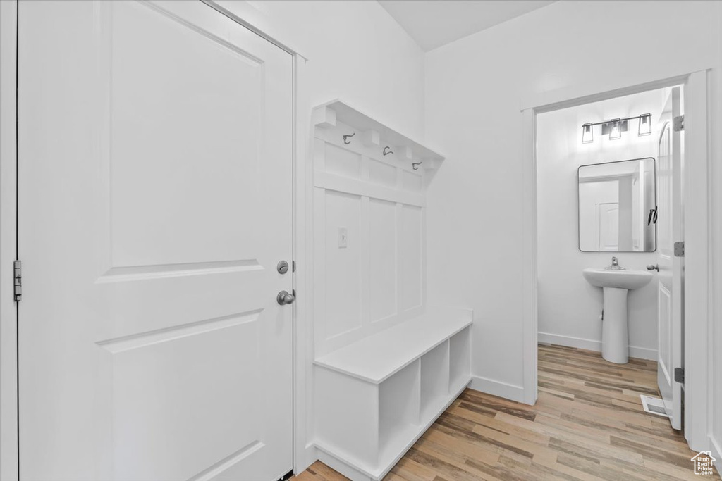 Mudroom featuring light wood-style floors and baseboards