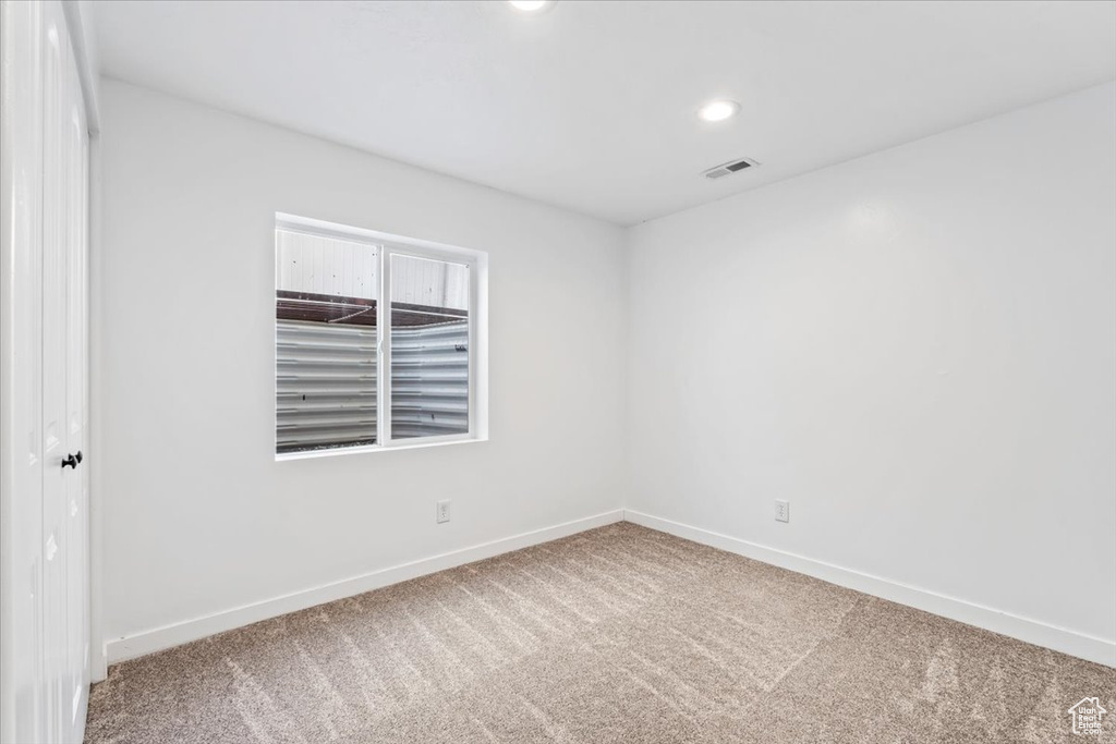 Carpeted spare room with baseboards and recessed lighting