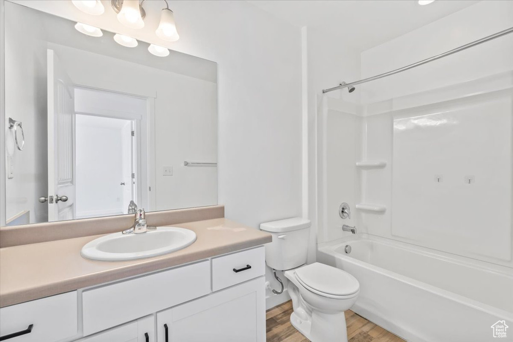 Bathroom with vanity, wood finished floors, and bathing tub / shower combination