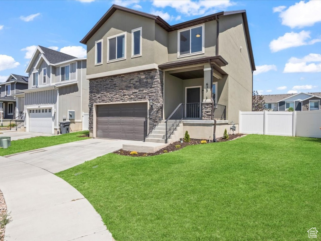 View of front of property featuring stone siding, an attached garage, a residential view, and stucco siding