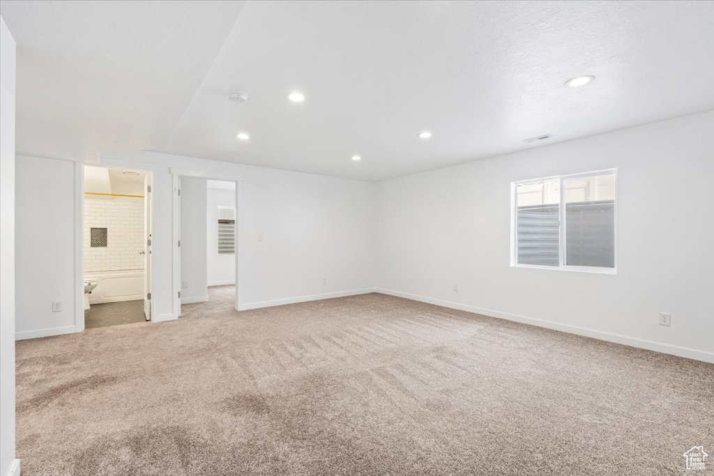 Empty room featuring light carpet, recessed lighting, and a smoke detector