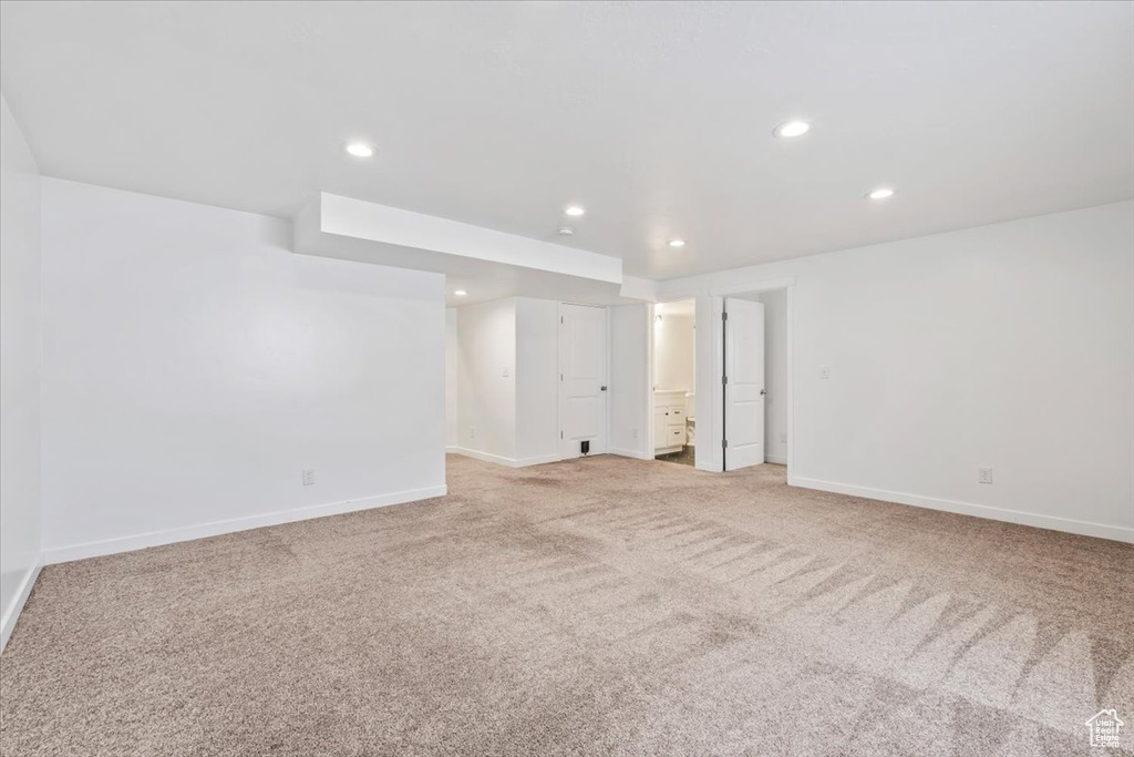 Empty room with light carpet and recessed lighting