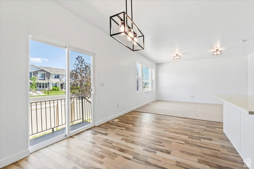Unfurnished dining area with light wood-style floors and a chandelier