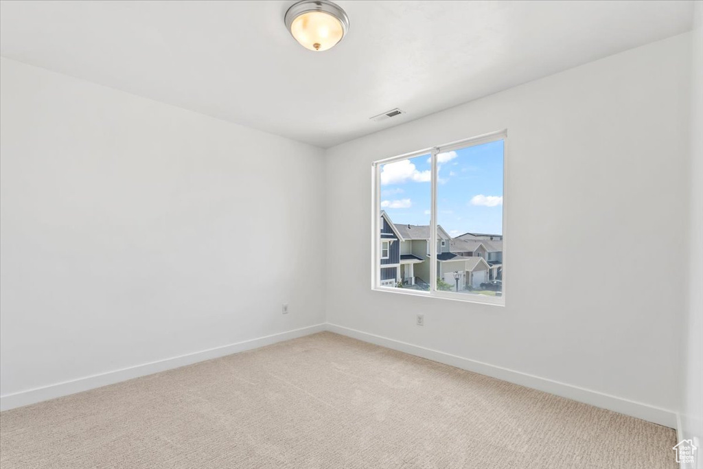 Unfurnished room featuring baseboards and light colored carpet