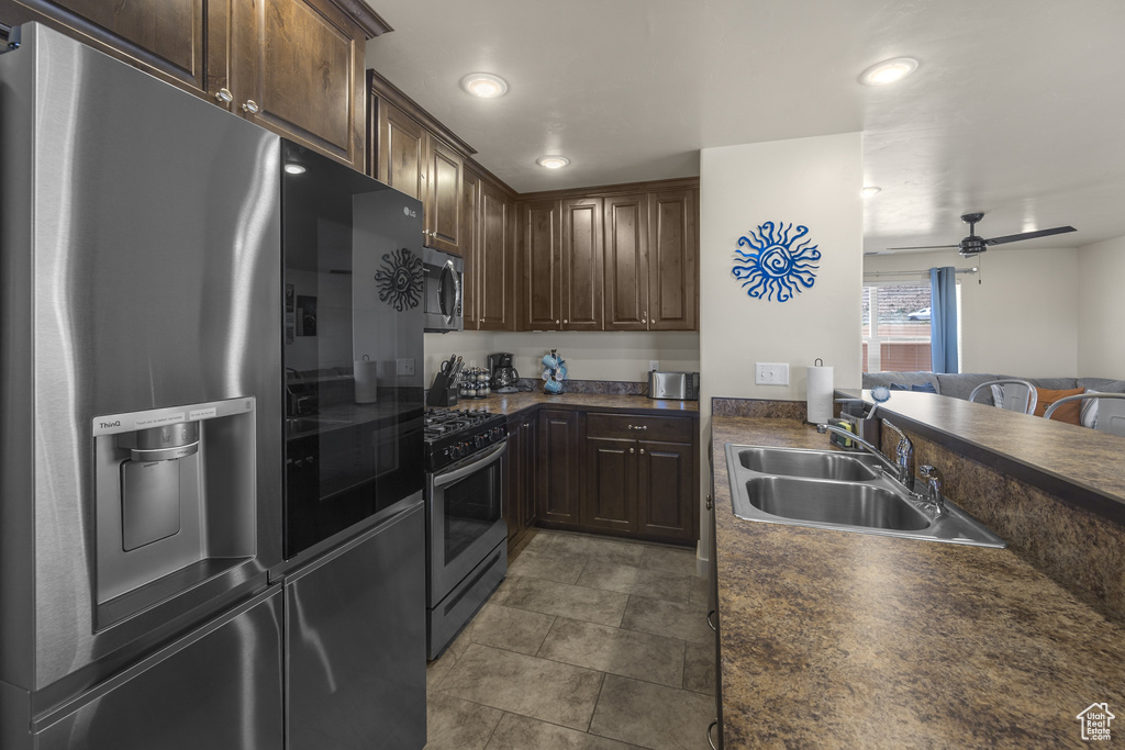 Kitchen featuring appliances with stainless steel finishes, dark countertops, dark brown cabinetry, ceiling fan, and recessed lighting
