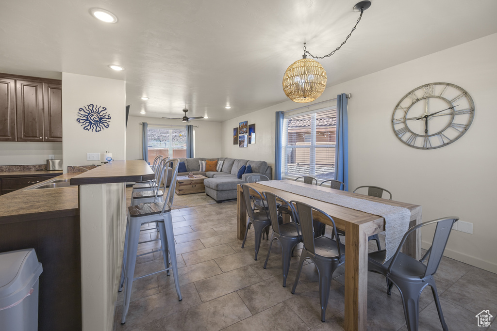 Dining space with a chandelier, tile patterned floors, and recessed lighting