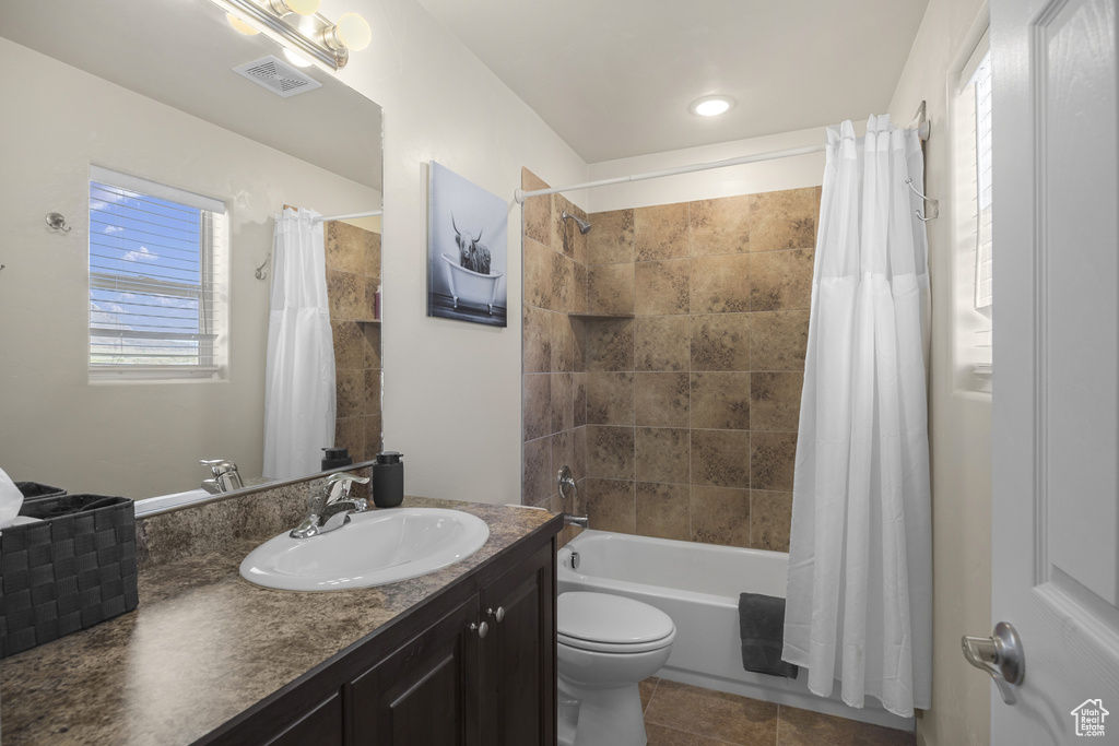 Full bathroom featuring vanity, shower / bathtub combination with curtain, and tile patterned flooring